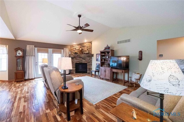 501 Flintlock Ct, Findlay, OH 45840 - living area with ceiling fan, vaulted ceiling, a stone fireplace, and wood finished floors