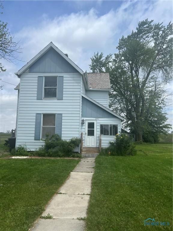 1218 Logan Ave, Findlay, OH 45840 - traditional-style house with board and batten siding, a front lawn, and a shingled roof