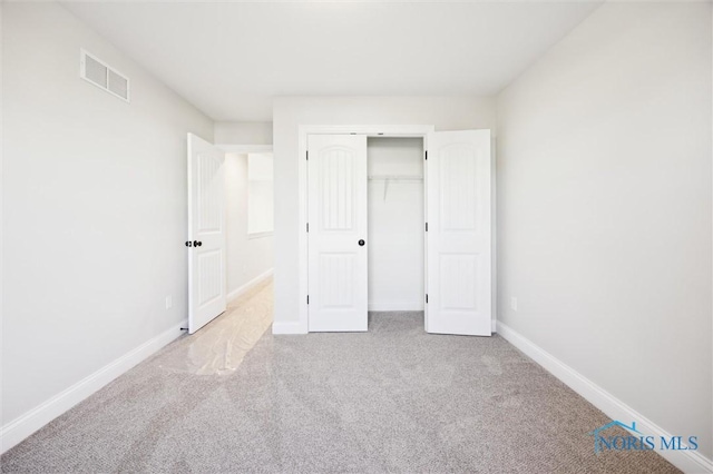 unfurnished bedroom featuring carpet flooring, baseboards, and a closet