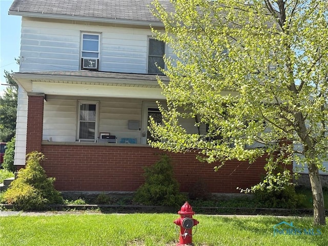 403 W Broadway St, North Baltimore, OH 45872 - view of front of property featuring brick siding, a front lawn, a porch, and a shingled roof