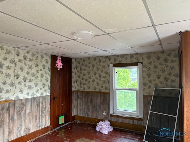 403 W Broadway St, North Baltimore, OH 45872 - empty room with wainscoting, a paneled ceiling, wood finished floors, and wallpapered walls