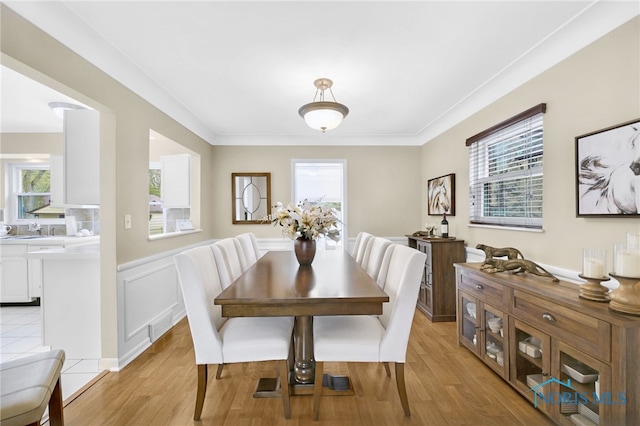 2324 Secor Rd, Toledo, OH 43606 - dining space with plenty of natural light, light wood-type flooring, a wainscoted wall, and crown molding