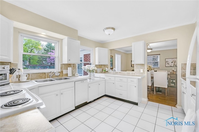 2324 Secor Rd, Toledo, OH 43606 - kitchen with light countertops, dishwasher, tasteful backsplash, white cabinetry, and crown molding