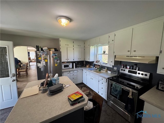5412 Evansport Rd, Defiance, OH 43512 - kitchen featuring stainless steel appliances, under cabinet range hood, a sink, arched walkways, and light countertops
