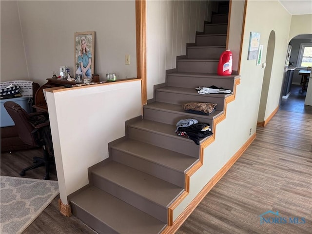 5412 Evansport Rd, Defiance, OH 43512 - stairs with arched walkways, wood finished floors, and baseboards