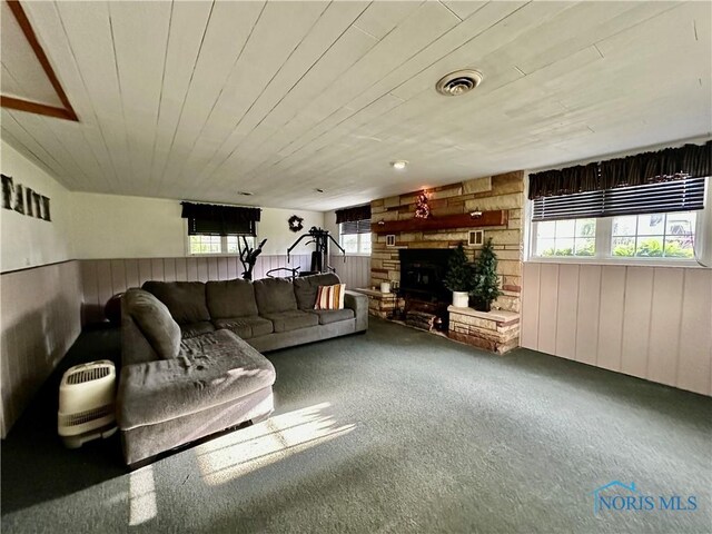 203 Washington St, Bettsville, OH 44815 - carpeted living area with wood walls, healthy amount of natural light, wood ceiling, and a stone fireplace