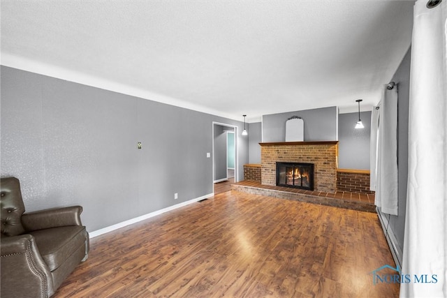 1473 State Route 66, Stryker, OH 43557 - living area featuring wood finished floors, baseboards, and a brick fireplace
