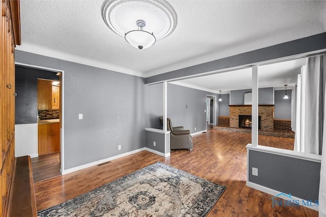 1473 State Route 66, Stryker, OH 43557 - living room with a textured ceiling, wood finished floors, a fireplace, and baseboards