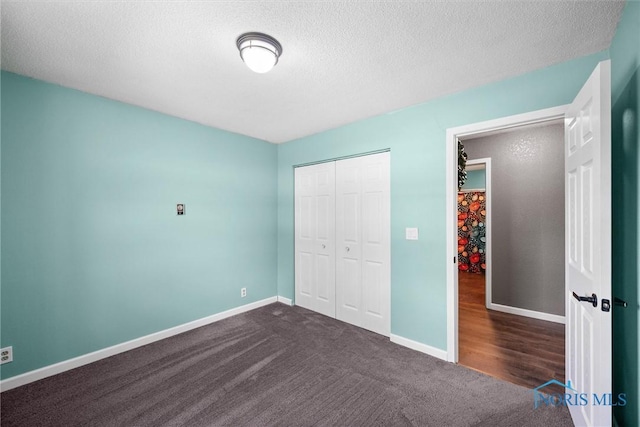 1473 State Route 66, Stryker, OH 43557 - unfurnished bedroom featuring dark colored carpet, a textured ceiling, baseboards, and a closet
