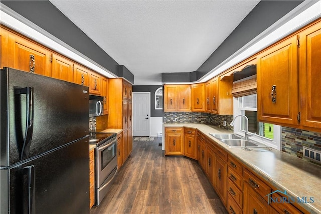 1473 State Route 66, Stryker, OH 43557 - kitchen with stainless steel appliances, a sink, dark wood-type flooring, and tasteful backsplash