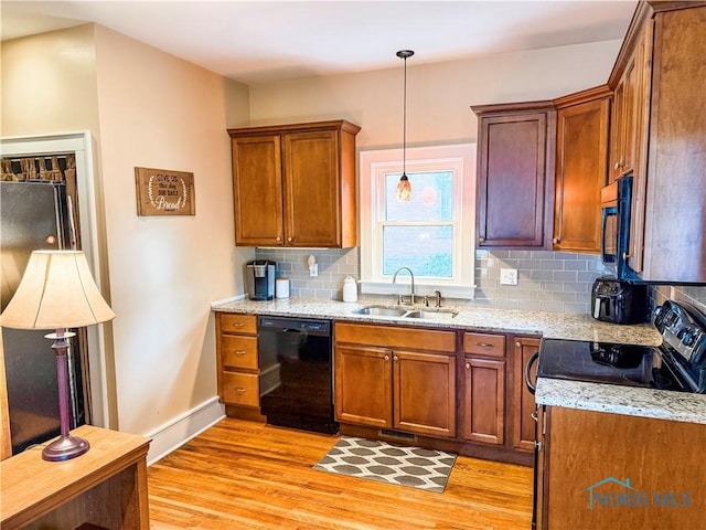 348 S 8th St, Upper Sandusky, OH 43351 - kitchen featuring black appliances, light wood finished floors, decorative backsplash, brown cabinets, and light stone counters