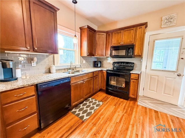 348 S 8th St, Upper Sandusky, OH 43351 - kitchen with black appliances, light wood finished floors, decorative light fixtures, and backsplash
