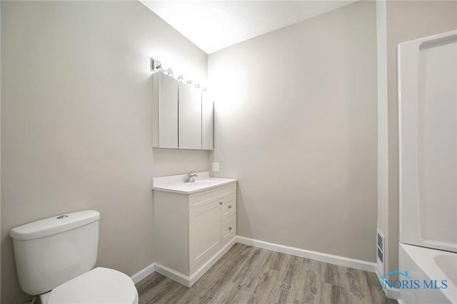 145 E Crocker St, Fostoria, OH 44830 - full bath with wood finished floors, toilet, vanity, baseboards, and a tub