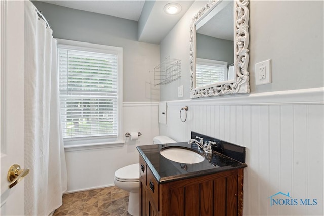 2904 Goddard Rd, Toledo, OH 43606 - bathroom with plenty of natural light, toilet, vanity, wainscoting, and baseboards