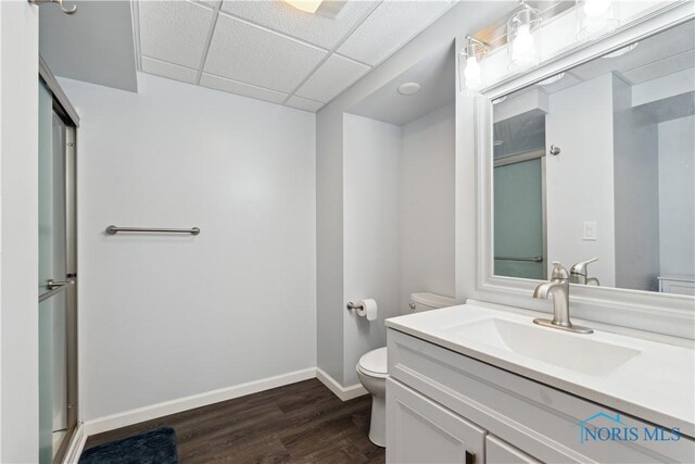 2904 Goddard Rd, Toledo, OH 43606 - bathroom with toilet, a paneled ceiling, wood finished floors, vanity, and baseboards