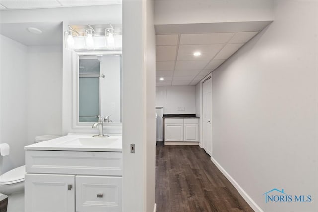 2904 Goddard Rd, Toledo, OH 43606 - bathroom featuring toilet, vanity, wood finished floors, a paneled ceiling, and recessed lighting