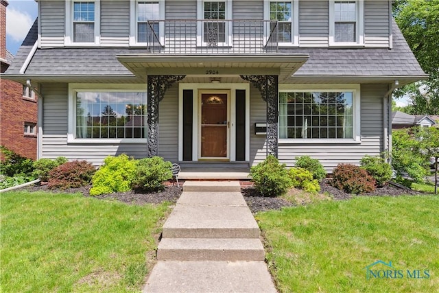 2904 Goddard Rd, Toledo, OH 43606 - view of front of house featuring roof with shingles, a front lawn, and covered porch