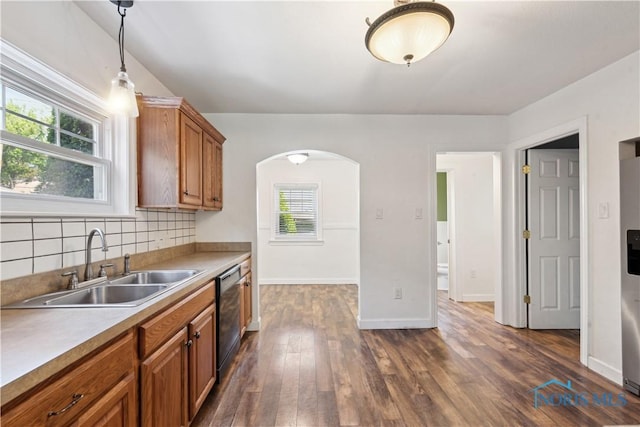 2904 Goddard Rd, Toledo, OH 43606 - kitchen with a sink, dishwashing machine, brown cabinets, arched walkways, and dark wood-style flooring