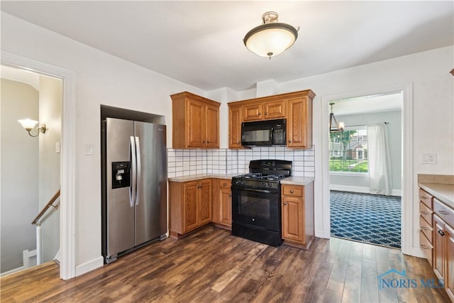 2904 Goddard Rd, Toledo, OH 43606 - kitchen with black appliances, light countertops, dark wood-type flooring, brown cabinets, and backsplash