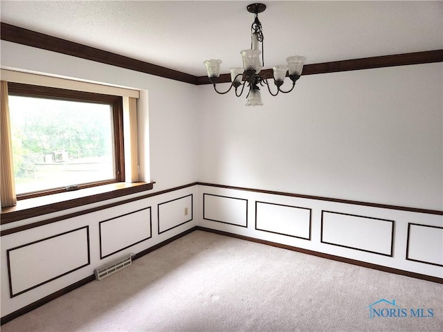 725 Ashbury Dr, Perrysburg, OH 43551 - unfurnished room featuring a chandelier, a decorative wall, carpet floors, a wainscoted wall, and crown molding
