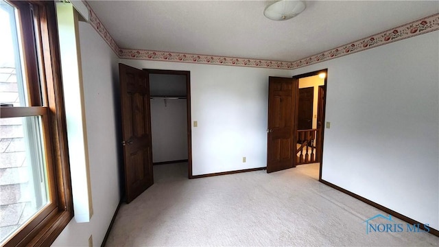 725 Ashbury Dr, Perrysburg, OH 43551 - unfurnished bedroom featuring light colored carpet, multiple windows, a closet, and a spacious closet
