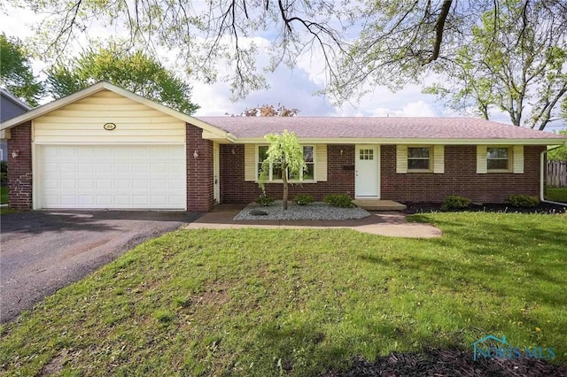1816 Cherry Ln, Findlay, OH 45840 - ranch-style house with asphalt driveway, a garage, brick siding, and a front yard