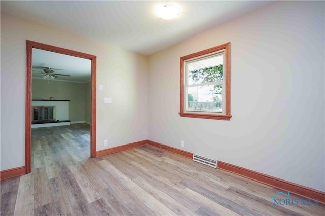 1816 Cherry Ln, Findlay, OH 45840 - spare room featuring light wood finished floors, a glass covered fireplace, a ceiling fan, and baseboards