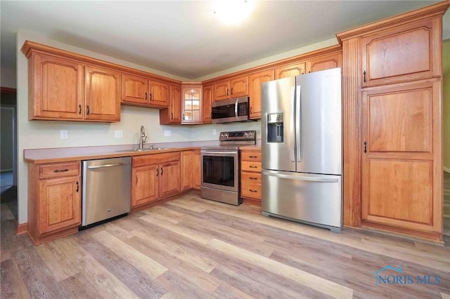 1816 Cherry Ln, Findlay, OH 45840 - kitchen featuring appliances with stainless steel finishes, light wood-type flooring, a sink, light countertops, and brown cabinets