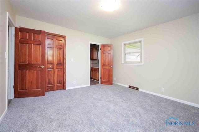 1816 Cherry Ln, Findlay, OH 45840 - unfurnished bedroom featuring carpet, baseboards, and connected bathroom