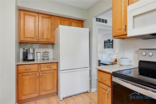 2009 Saratoga Dr, Findlay, OH 45840 - kitchen with white appliances, backsplash, light wood-type flooring, light stone countertops, and brown cabinets