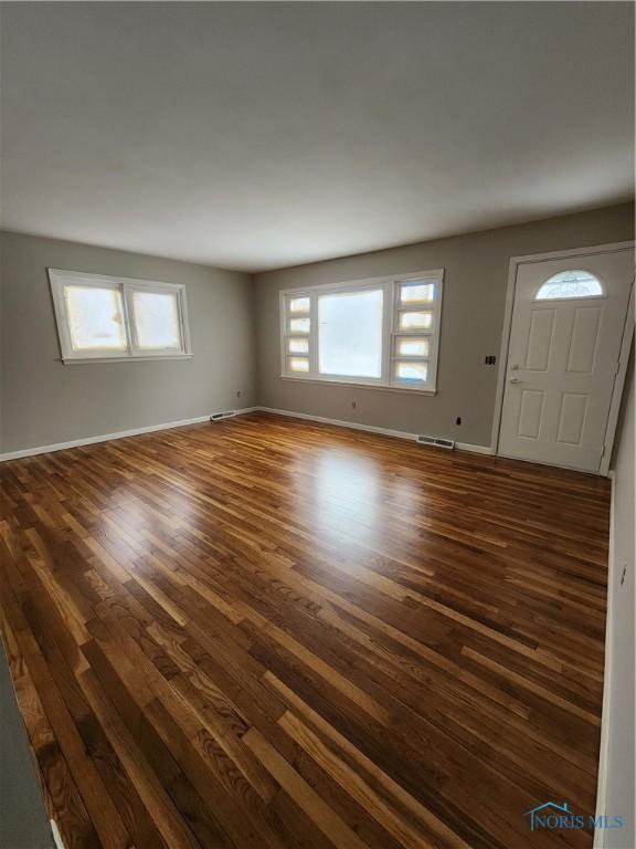 514 E Indiana, Maumee, OH 43537 - unfurnished living room with dark wood-style flooring and baseboards