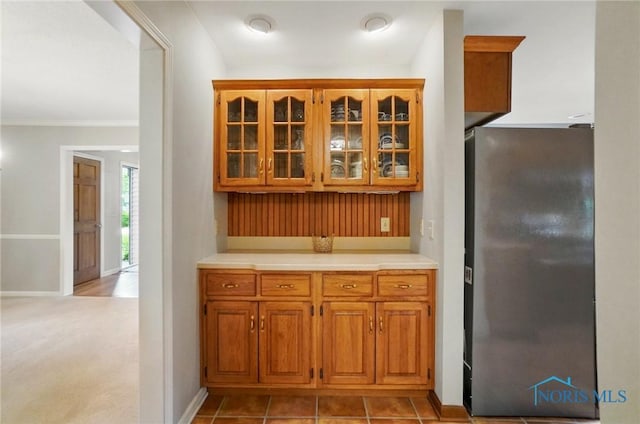 1301 Forest Park, Findlay, OH 45840 - kitchen featuring freestanding refrigerator, brown cabinetry, light countertops, glass insert cabinets, and baseboards
