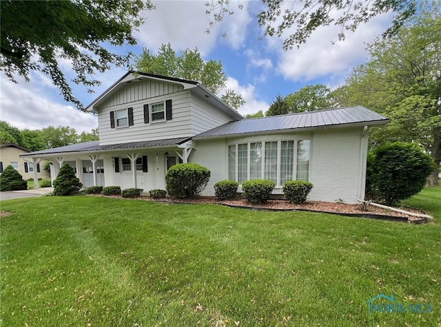 212 Duck Pond Rd, Upper Sandusky, OH 43351 - view of front facade featuring a front yard, metal roof, and brick siding