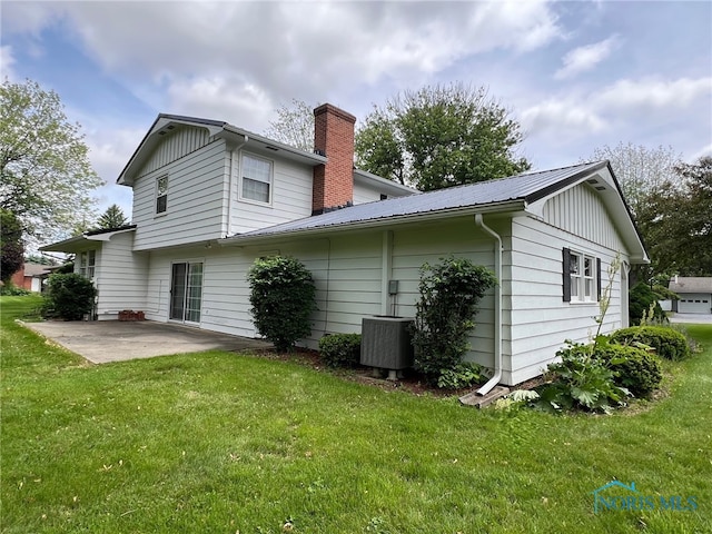 212 Duck Pond Rd, Upper Sandusky, OH 43351 - back of property with a patio area, central AC, a chimney, a yard, and metal roof