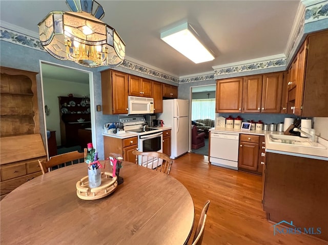 212 Duck Pond Rd, Upper Sandusky, OH 43351 - kitchen with white appliances, a sink, light wood finished floors, brown cabinets, and crown molding