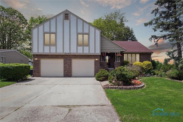 2142 Tracy Rd, Northwood, OH 43619 - tudor-style house featuring brick siding, driveway, a front yard, and a garage