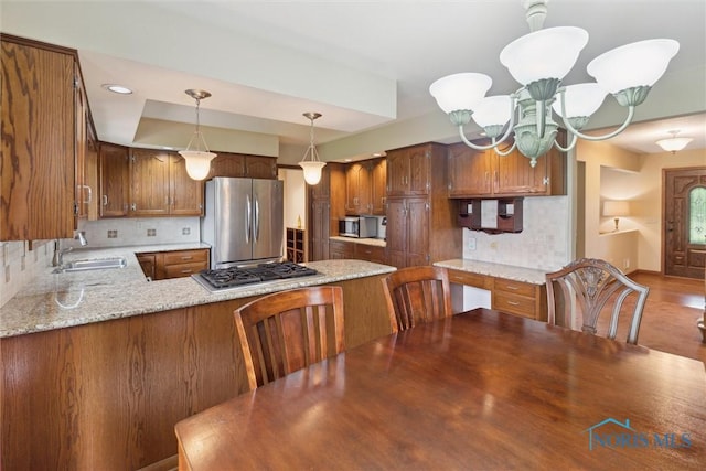 2142 Tracy Rd, Northwood, OH 43619 - kitchen featuring appliances with stainless steel finishes, a sink, backsplash, and a peninsula