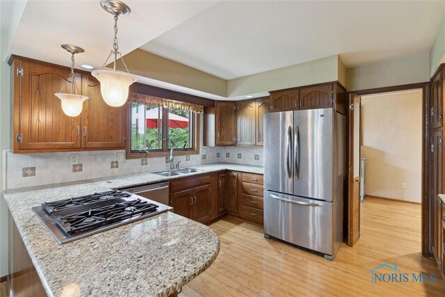 2142 Tracy Rd, Northwood, OH 43619 - kitchen featuring appliances with stainless steel finishes, a sink, light wood-style floors, and a peninsula