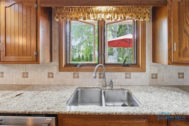 2142 Tracy Rd, Northwood, OH 43619 - kitchen with a sink, brown cabinets, backsplash, and dishwasher