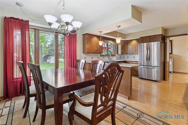 2142 Tracy Rd, Northwood, OH 43619 - dining room featuring a chandelier, baseboards, and light wood-style floors