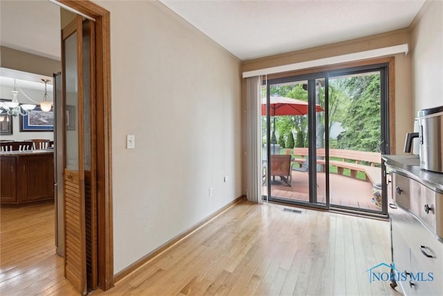 2142 Tracy Rd, Northwood, OH 43619 - unfurnished room featuring light wood-type flooring, baseboards, and a chandelier