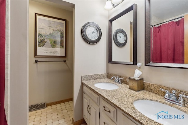 2142 Tracy Rd, Northwood, OH 43619 - bathroom featuring tile patterned floors, double vanity, and baseboards