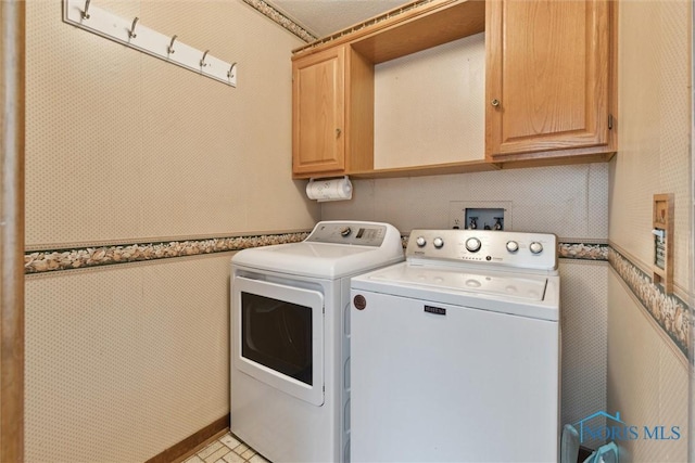2142 Tracy Rd, Northwood, OH 43619 - laundry room featuring washing machine and clothes dryer, cabinet space, and wallpapered walls