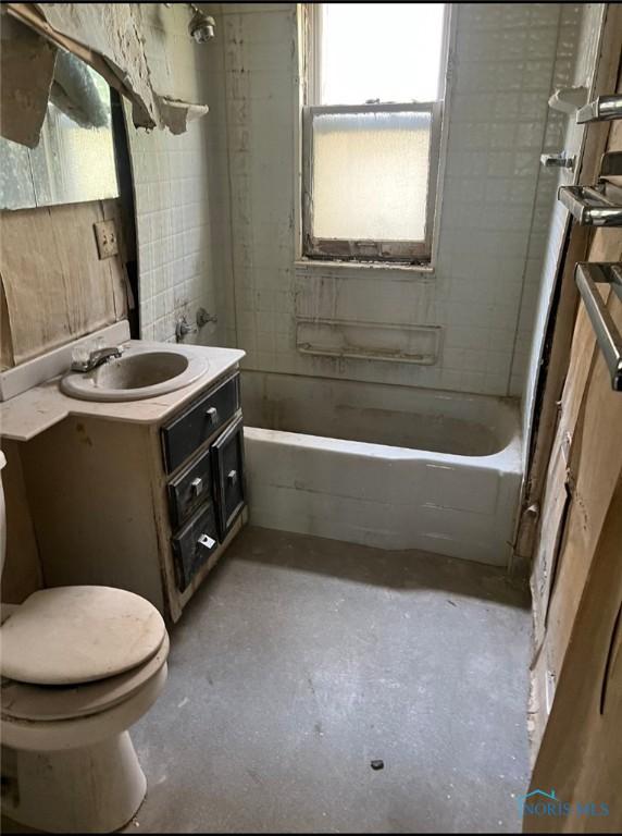 636 Nesslewood Ave, Toledo, OH 43610 - bathroom featuring unfinished concrete flooring, toilet, vanity, and bathtub / shower combination