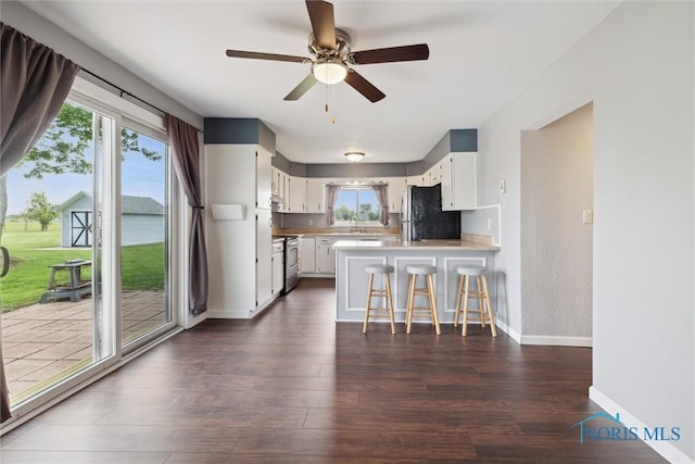 10540 Veler Rd, Curtice, OH 43412 - kitchen featuring freestanding refrigerator, stainless steel range oven, a peninsula, baseboards, and light countertops