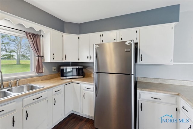 10540 Veler Rd, Curtice, OH 43412 - kitchen featuring stainless steel appliances, a sink, light countertops, and white cabinets