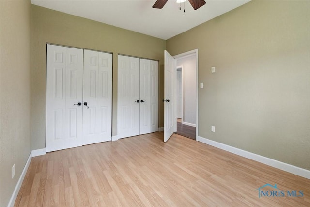 10540 Veler Rd, Curtice, OH 43412 - unfurnished bedroom featuring two closets, light wood-style floors, baseboards, and ceiling fan