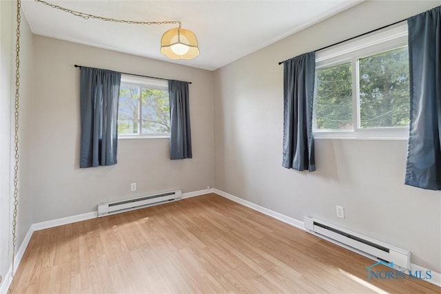 10540 Veler Rd, Curtice, OH 43412 - spare room with a baseboard heating unit, wood finished floors, and baseboards