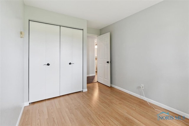 10540 Veler Rd, Curtice, OH 43412 - unfurnished bedroom featuring light wood-type flooring, baseboards, and a closet