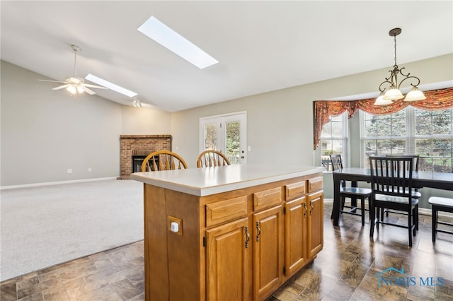 209 E Sawmill Rd, Findlay, OH 45840 - kitchen with lofted ceiling, a fireplace, stone finish floors, baseboards, and a kitchen island